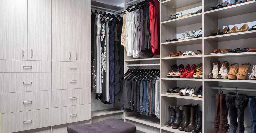 A walk-in closet with cabinets, drawers, and open shelves