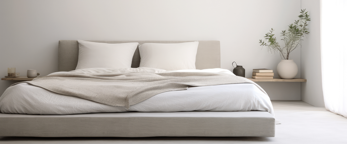 A serene, minimalist bedroom with a neutral color palette, featuring a low platform bed, simple decor