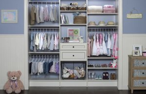 White kids' closet organizer in blue room with toys