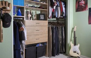Natural wood kids' closet organizer system in green room with guitar