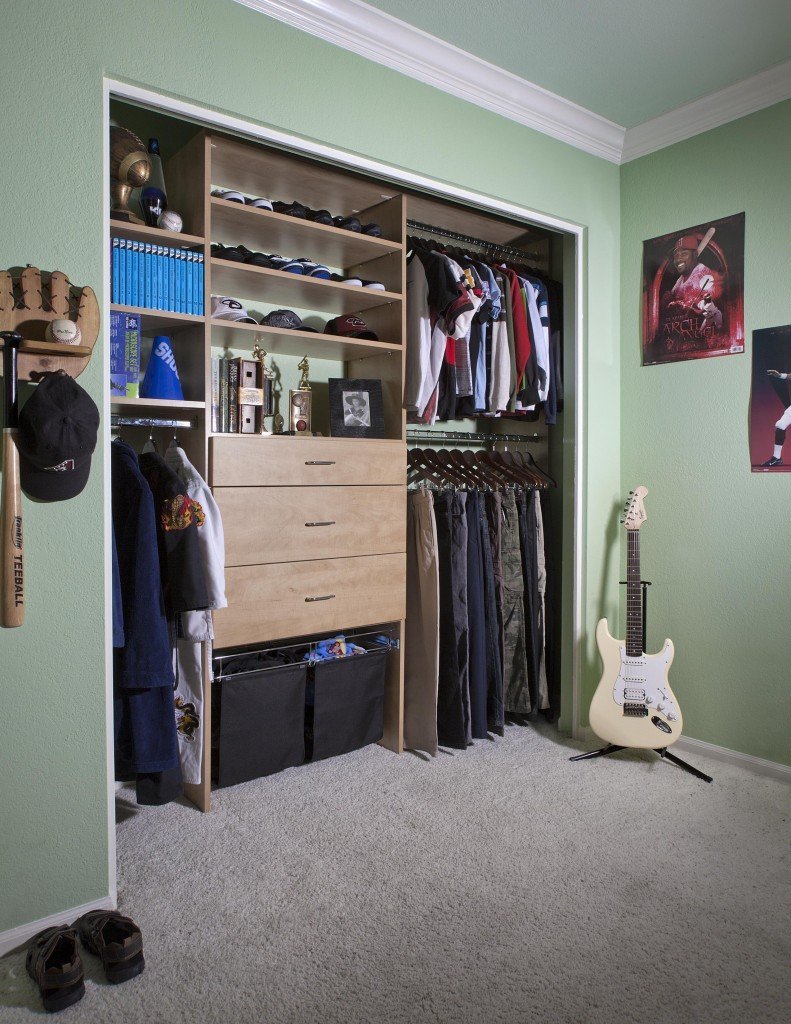 Custom kids' closet organization system in bright green room with sports equipment and guitar