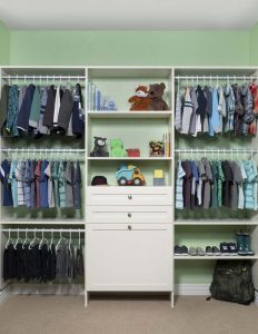 Clothes, shoes, and toys inside reach-in closet system in bright green kids' room