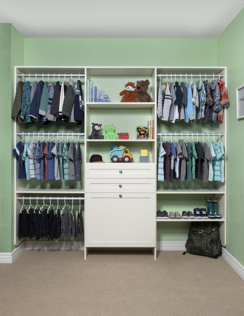 Clothes, shoes, and toys stored in kids' closet in light green room