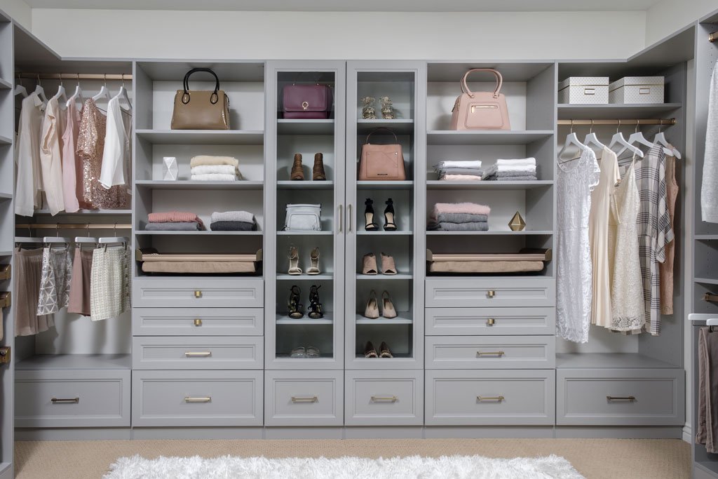 Front view of walk-in closet organization system stocked with clothes, shoes, and accessories