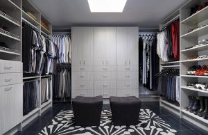 Large walk-in closet system in gray wood with two seats on floor