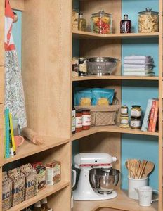 Kitchen pantry organization system in corner of bright blue room