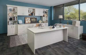 White cabinets and desk in blue home office with large view from windows
