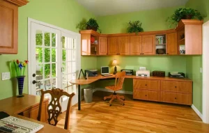 Corner home office setup with light wood cabinets and chairs