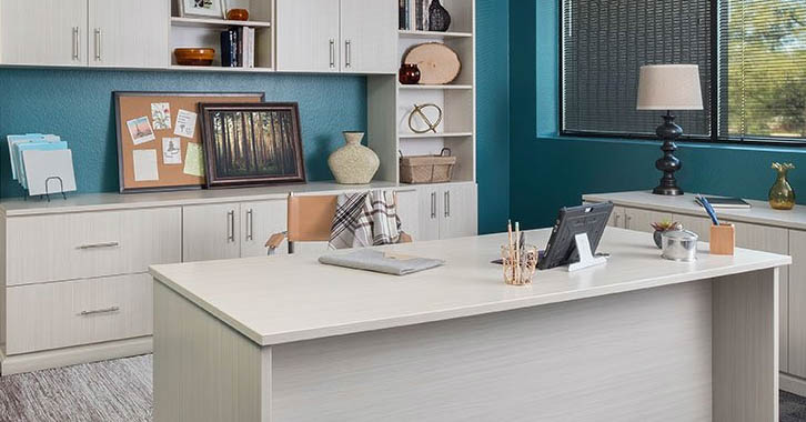 A home office with white cabinets