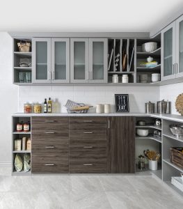 Gray kitchen cabinets with glass-front doors and brown drawer fronts in white kitchen