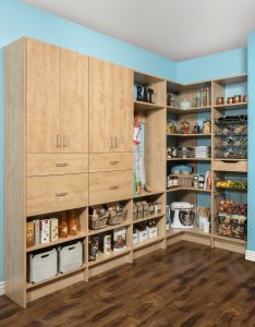 Natural wood pantry closet organizer system in bright blue room