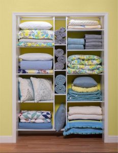 New white shelving in reach-in linen closet