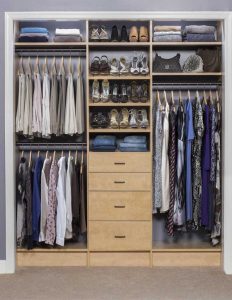 Natural wood closet organizer system with hanging racks and drawers