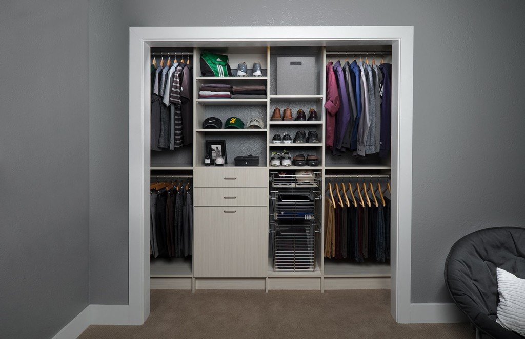 Front view of reach-in closet organization system stocked with clothes, shoes, and accessories