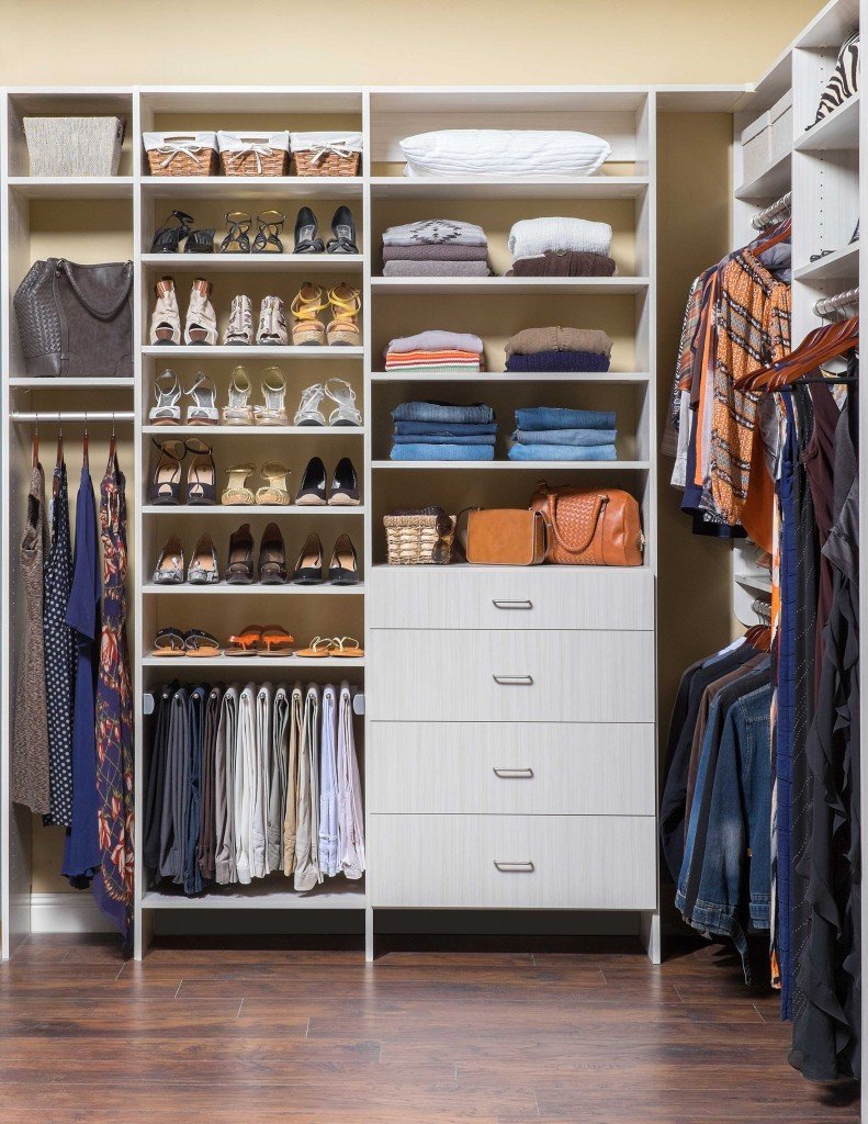 Shoes, handbags, and clothes stored in closet organization system