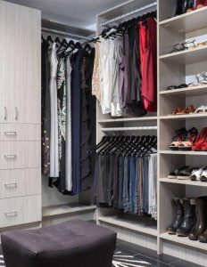 Light gray closet organization system with clothes hanging on racks