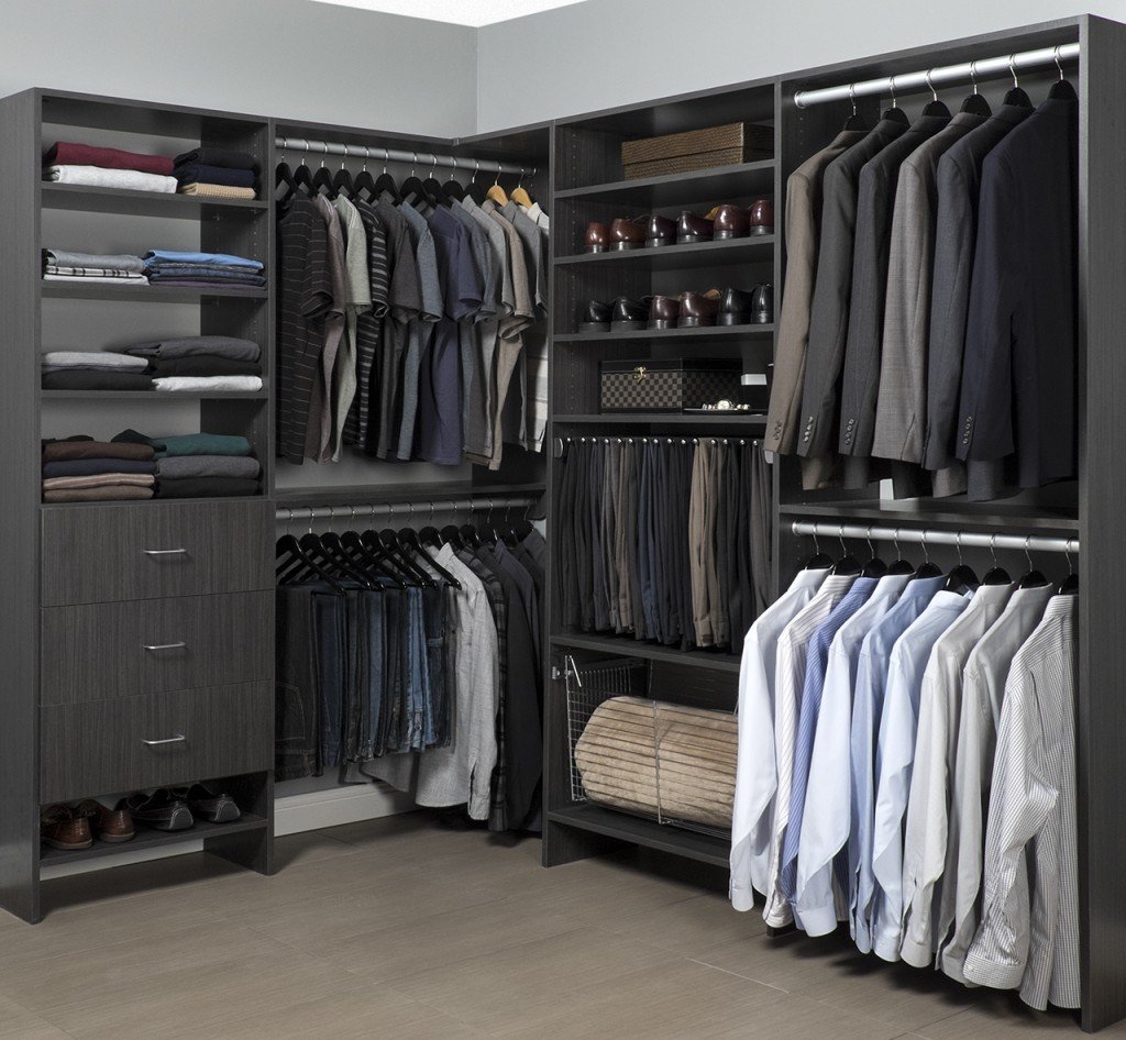 Corner view of walk-in closet organization system stocked with men's clothes, shoes, and accessories