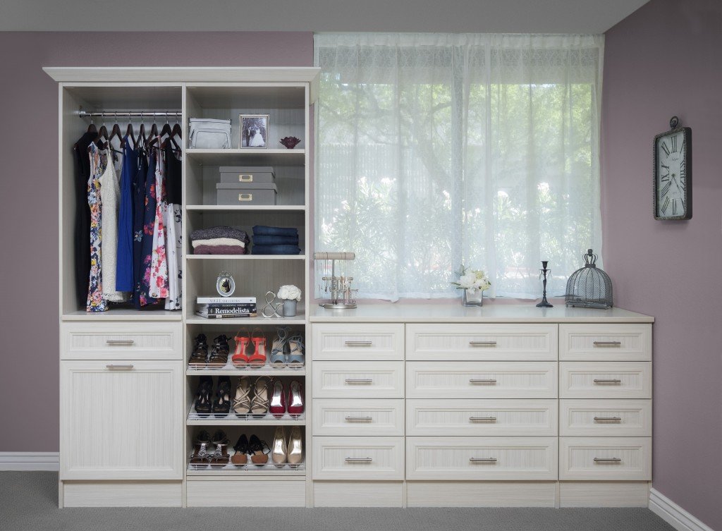 Small closet organization system stocked with clothes, shoes, and accessories