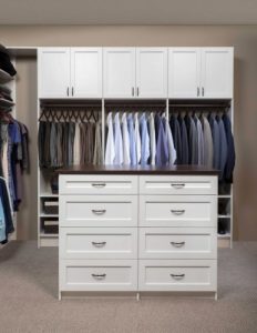 interior of closet with island, clothing racks, and cabinets