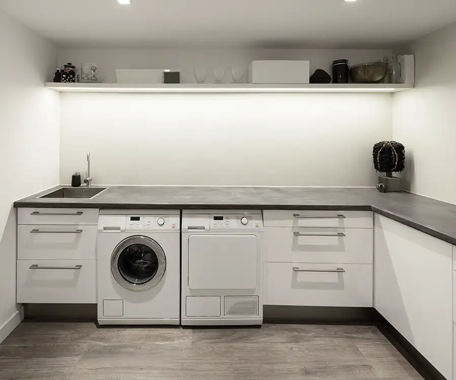 big laundry room with white and lit cabinetry