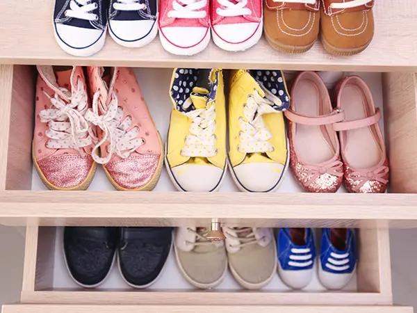 opened drawer and shelves with colorful shoes inside
