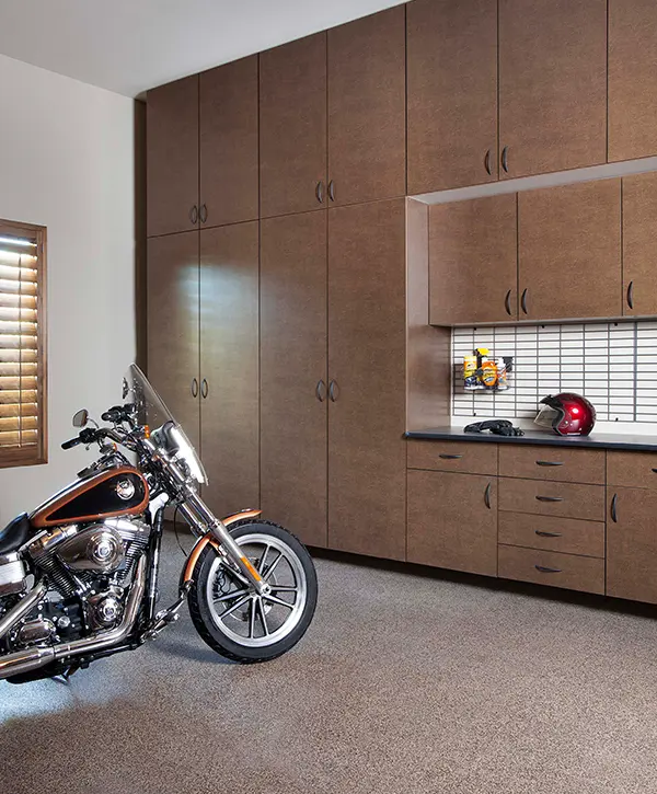 A motorbike in a garage with large cabinets