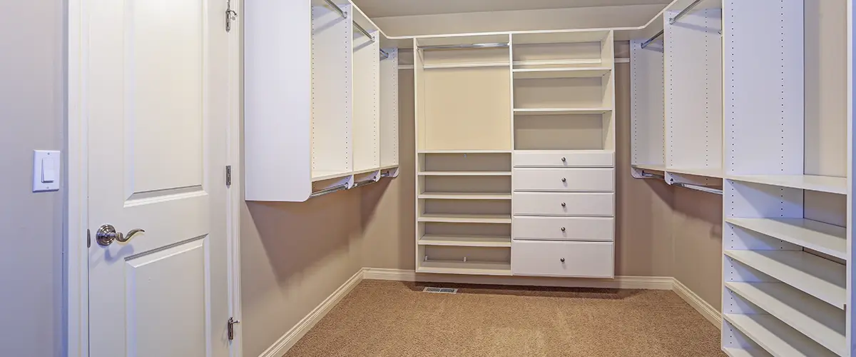 A large, empty closet in a room with carpet flooring