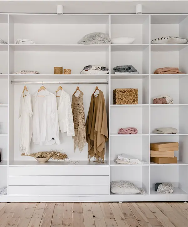 A white reach-in closet with many open shelves and a few drawers