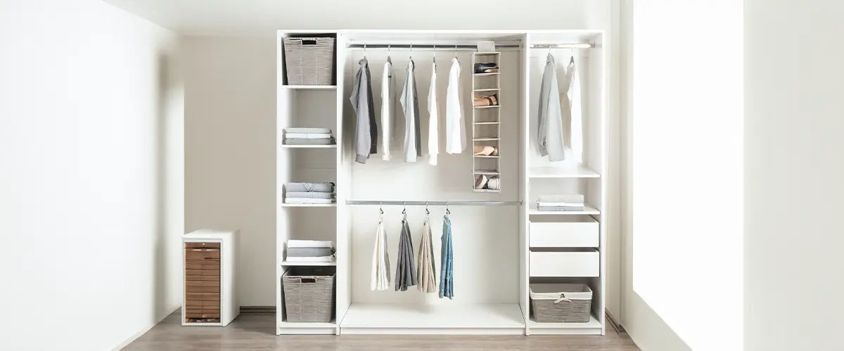 a small white walk in closet with open shelving and shelves holding baskets