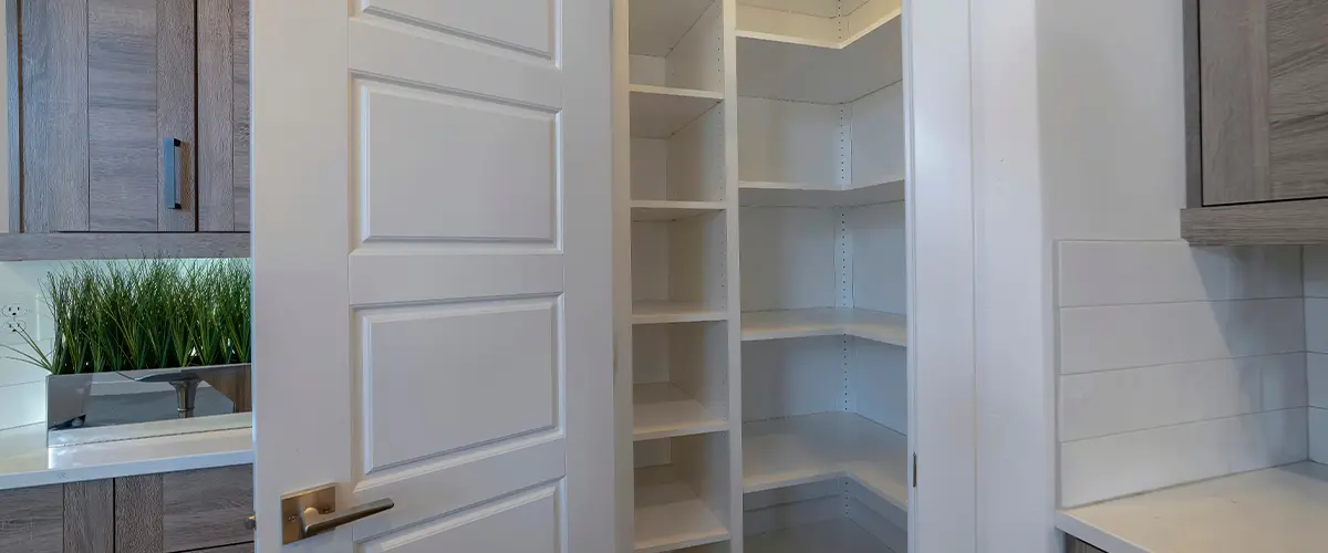 Small pantry with empty wall shelves at the corner of the kitchen of home