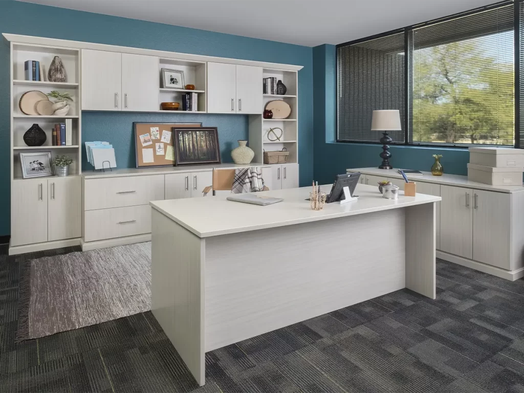 White cabinets and desk home office with blue accent wall.
